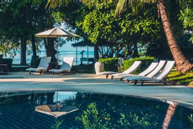 Güzel lüks otel ve tatil seyahat ve tatil için sandalye ve şemsiye ile açık yüzme havuzu