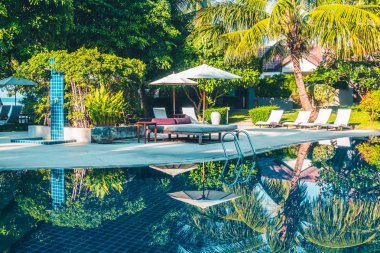 Güzel lüks otel ve tatil seyahat ve tatil için sandalye ve şemsiye ile açık yüzme havuzu