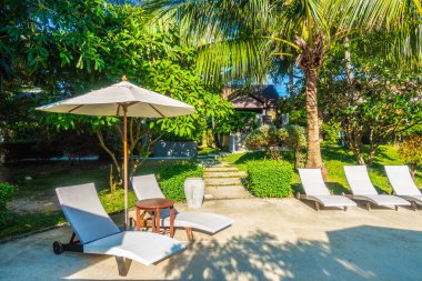 Güzel lüks otel ve tatil seyahat ve tatil için sandalye ve şemsiye ile açık yüzme havuzu