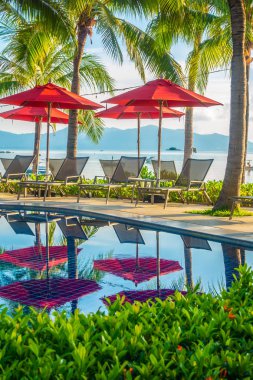 Güzel lüks otel ve tatil seyahat ve tatil için sandalye ve şemsiye ile açık yüzme havuzu