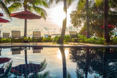 Güzel lüks otel ve tatil seyahat ve tatil için sandalye ve şemsiye ile açık yüzme havuzu