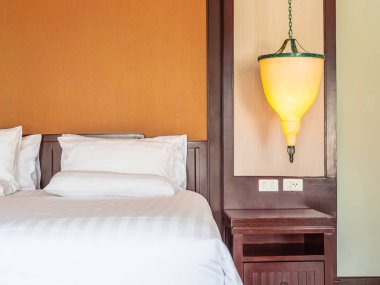 Otel yatak odasında ışık lamba dekorasyonu ile yatakta rahat yastık