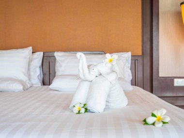 Beyaz fil havlu ve yatak otel yatak odası iç dekorasyonda rahat yastık