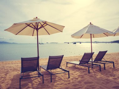 Şemsiye ve tropikal plaj deniz ve okyanus gündoğumu zaman seyahat ve tatil için sandalye