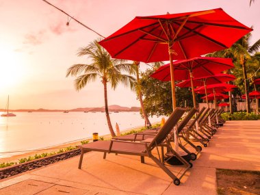 Şemsiye ve sandalye açık yüzme havuzunda otel ve gündoğumu zaman resort çevresinde