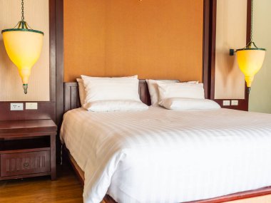 Otel yatak odasında ışık lamba dekorasyonu ile yatakta rahat yastık