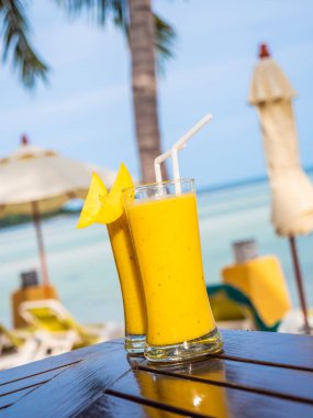 Mango smoothies ve deniz okyanus manzarası ile içme cam buzlu