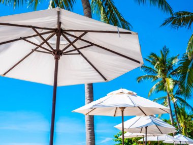 Hindistan cevizi hurma ağacı ile deniz okyanus seyahat ve tatil için mavi gökyüzü arka plan üzerinde Beyaz şemsiye