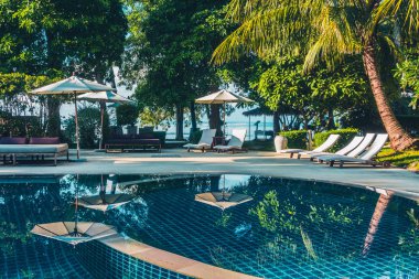 Güzel lüks otel ve tatil seyahat ve tatil için sandalye ve şemsiye ile açık yüzme havuzu