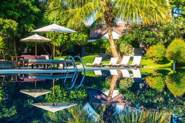 Güzel lüks otel ve tatil seyahat ve tatil için sandalye ve şemsiye ile açık yüzme havuzu