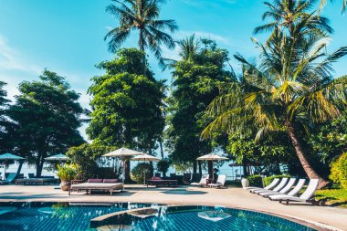 Güzel lüks otel ve tatil seyahat ve tatil için sandalye ve şemsiye ile açık yüzme havuzu