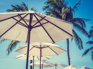 Hindistan cevizi hurma ağacı ile deniz okyanus seyahat ve tatil için mavi gökyüzü arka plan üzerinde Beyaz şemsiye