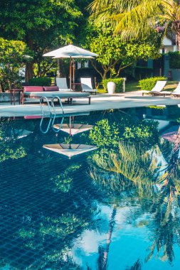 Güzel lüks otel ve tatil seyahat ve tatil için sandalye ve şemsiye ile açık yüzme havuzu