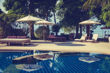 Güzel lüks otel ve tatil seyahat ve tatil için sandalye ve şemsiye ile açık yüzme havuzu