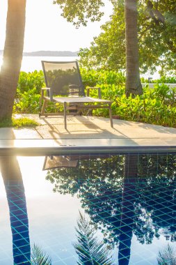 Güzel lüks otel ve tatil seyahat ve tatil için sandalye ve şemsiye ile açık yüzme havuzu