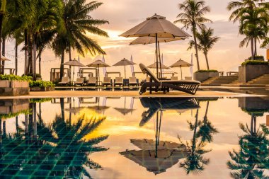 Güzel lüks otel ve tatil seyahat ve tatil için sandalye ve şemsiye ile açık yüzme havuzu