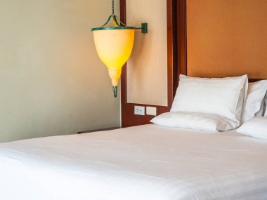 Otel yatak odasında ışık lamba dekorasyonu ile yatakta rahat yastık