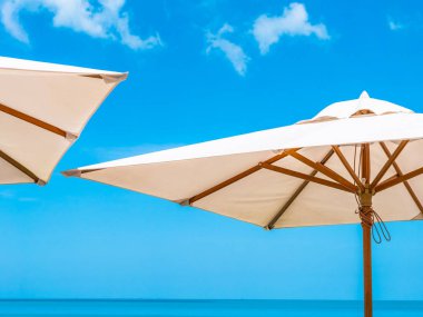 Hindistan cevizi hurma ağacı ile deniz okyanus seyahat ve tatil için mavi gökyüzü arka plan üzerinde Beyaz şemsiye