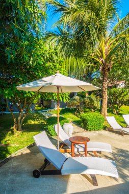 Güzel lüks otel ve tatil seyahat ve tatil için sandalye ve şemsiye ile açık yüzme havuzu