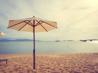 Şemsiye ve tropikal plaj deniz ve okyanus gündoğumu zaman seyahat ve tatil için sandalye