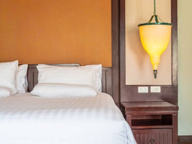 Otel yatak odasında ışık lamba dekorasyonu ile yatakta rahat yastık
