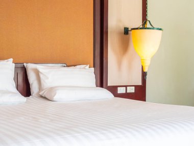 Otel yatak odasında ışık lamba dekorasyonu ile yatakta rahat yastık