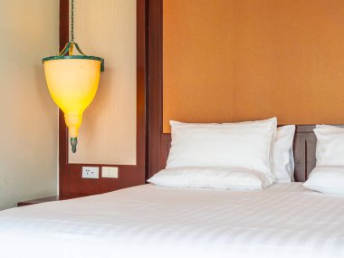 Otel yatak odasında ışık lamba dekorasyonu ile yatakta rahat yastık
