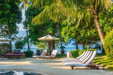 Güzel lüks otel ve tatil seyahat ve tatil için sandalye ve şemsiye ile açık yüzme havuzu
