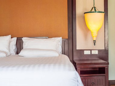 Otel yatak odasında ışık lamba dekorasyonu ile yatakta rahat yastık