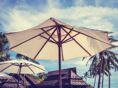 Hindistan cevizi hurma ağacı ile deniz okyanus seyahat ve tatil için mavi gökyüzü arka plan üzerinde Beyaz şemsiye