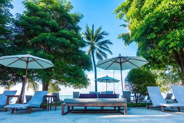 Güzel lüks otel ve tatil seyahat ve tatil için sandalye ve şemsiye ile açık yüzme havuzu
