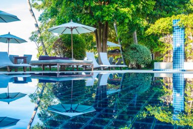 Güzel lüks otel ve tatil seyahat ve tatil için sandalye ve şemsiye ile açık yüzme havuzu