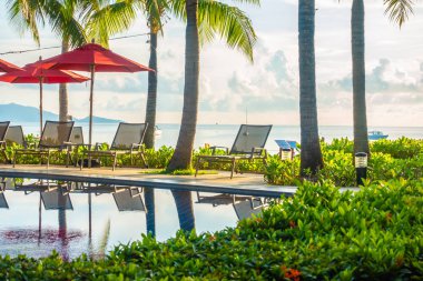 Güzel lüks otel ve tatil seyahat ve tatil için sandalye ve şemsiye ile açık yüzme havuzu