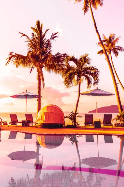 Şemsiye ve lüks otel ve gündoğumu zaman seyahat ve tatil için Resort'ta yüzme havuzu etrafında sandalye ile güzel açık görünüm