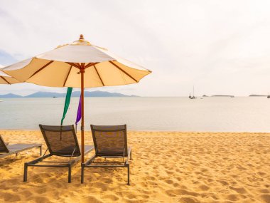 Şemsiye ve tropikal plaj deniz ve okyanus gündoğumu zaman seyahat ve tatil için sandalye