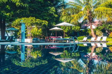 Güzel lüks otel ve tatil seyahat ve tatil için sandalye ve şemsiye ile açık yüzme havuzu