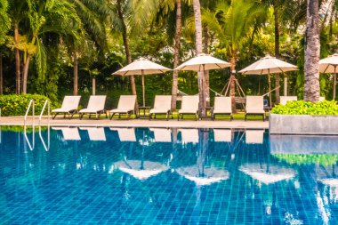 Güzel lüks otel ve tatil seyahat ve tatil için sandalye ve şemsiye ile açık yüzme havuzu