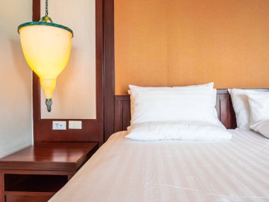 Otel yatak odasında ışık lamba dekorasyonu ile yatakta rahat yastık