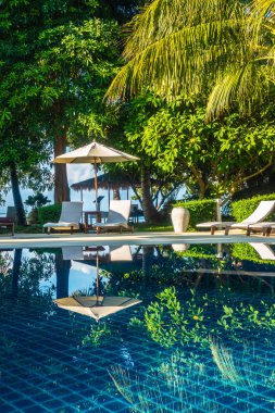 Güzel lüks otel ve tatil seyahat ve tatil için sandalye ve şemsiye ile açık yüzme havuzu