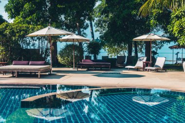 Güzel lüks otel ve tatil seyahat ve tatil için sandalye ve şemsiye ile açık yüzme havuzu