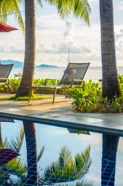 Güzel lüks otel ve tatil seyahat ve tatil için sandalye ve şemsiye ile açık yüzme havuzu