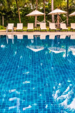 Güzel lüks otel ve tatil seyahat ve tatil için sandalye ve şemsiye ile açık yüzme havuzu