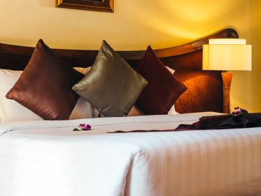 Otel yatak odasında ışık lamba dekorasyonu ile yatakta rahat yastık