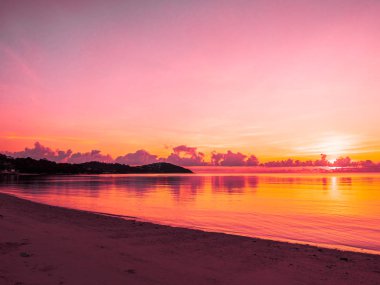 Güzel tropikal plaj ve okyanus yatay, bulut ve gökyüzü gündoğumu veya günbatımı zaman seyahat ve tatil için