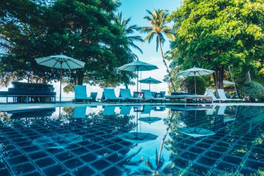 Güzel lüks otel ve tatil seyahat ve tatil için sandalye ve şemsiye ile açık yüzme havuzu