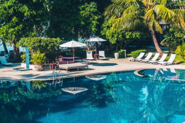 Güzel lüks otel ve tatil seyahat ve tatil için sandalye ve şemsiye ile açık yüzme havuzu