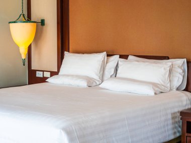 Otel yatak odasında ışık lamba dekorasyonu ile yatakta rahat yastık