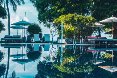 Güzel lüks otel ve tatil seyahat ve tatil için sandalye ve şemsiye ile açık yüzme havuzu