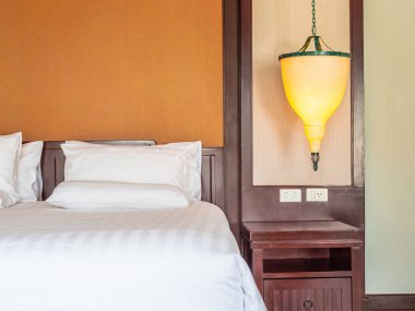 Otel yatak odasında ışık lamba dekorasyonu ile yatakta rahat yastık
