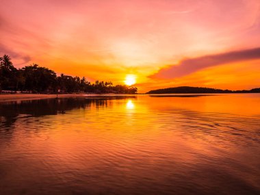 Güzel tropikal plaj deniz ve okyanus ile Hindistan cevizi hurma ağacı gündoğumu zaman seyahat ve tatil için